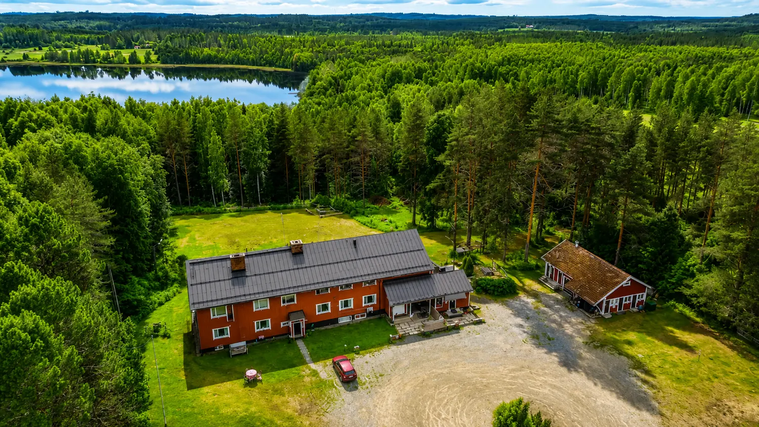 Aerial view of Wanha Koulu, the old schoolhouse near Tahko, surrounded by forest and lake